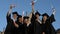 Finally free. Group of cheerful students wearing graduation gown