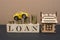 Finance and car loans, car savings, mortgages. A yellow car and a wooden house. Wooden cubes with the word LOAN. Copy space for te
