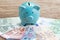 Finance money savings account, Europe economics concept, blue piggy bank on pile of Euro banknotes on wooden table, future growth