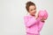 Finance. portrait of a girl in a pink suit holding a piggy bank on a white background with copy space