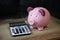 Finance savings cute pink piggy bank with calculator