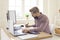 Financial accountant writing something down while working on computers at his office desk