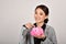 Financial adviser money saving expert, Asian business woman smiling and holding pink piggy bank.