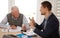 Financial advisor talking to a senior man with an investment, savings or retirement planning. Discussion, documents and