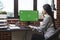 Financial agency office worker sitting at computer with chroma key blank screen.