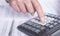 Financial analysis concept, male hands using a calculator over accounting documents, extra closeup