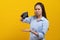 Financial bankruptcy girl opening empty wallet and worrying face isolated on yellow background