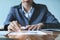 The financial concept of an auditor. A businessman works on a notebook using stock information documents in her office