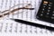 Financial concept. Calculator, pen and glasses on financial documents. Financial accounting. Balance sheets. Closeup of financial