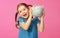 Financial concept of children`s pocket money. child girl with piggy Bank      on a colored pink background