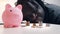 Financial decision, investments and savings. African american man looking into the coins in front of the piggy bank.