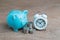 Financial long term saving money, debt control concept, blue piggy bank, coins stacked and alarm clock on wood table, compound