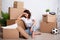 Financial or relationship problems - young stressful woman sitting with cardboard boxes