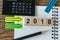 financial target concept as selective focus on number 2018 wooden block with calculator, pencil, notebook, arrow stick paper