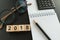 financial target concept as selective focus on number 2018 wooden block with glasses, calculator, pencil, notebook.