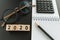 financial target or goal concept as selective focus on number 2020 wooden block with glasses, calculator, pencil, notebook