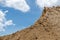 Find Granular sand pile with cloudy sky.