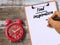 Find inspiration handwritten on clipboard and red alarm clock on wood table