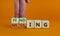 Finding or missing symbol. Businessman turns wooden cubes and changes the word missing to finding. Beautiful orange background.