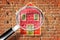 Finding the right home for you! - Concept image with home against a brick wall seen through a magnifying glass