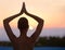 Finding tranquility in nature. A beautiful young woman in a yoga pose at sunset.