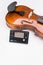 fine acoustic violin and electronic tuner on a white background