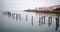 Fine art landscape image of derelict pier in milky long exposure