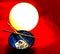 Fine art with porcelain bowl, chopsticks, a lamp on a red cloudy background.