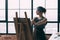 Fine art school young lady learning paint easel