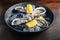 Fine de Claire Oyster and lemon served in black bowl with ice on wooden table