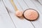 Fine pink Himalayan salt in wooden spoon on a white wooden background