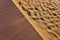 Fine yellow warm sand and wooden floor. Contrast of two materials. Rich textured shot