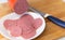 Finely chopped salami ham in white plate on wood background