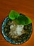 Finely grated radish with soy sauce in a bowl of blue white porcelain with a green leaf for decoration, Japanese garnish