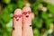 Finger art of a Happy couple. A man and a woman hug in pink glasses in shape of hearts.