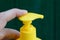 Finger clicks on a yellow plastic dispenser in a bottle
