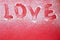 Finger drawn blur word Love on a snowy red background. Happy valentines day greeting card