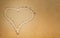 Finger drawn heart on the sand, symbol of love