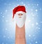 Finger dressed in Santa-Claus red-white hat