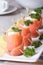 Finger food. Rolls of salmon closeup on the table vertical