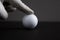 Finger in glove touch golf ball black background