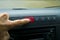 Finger hitting car emergency red light button in the car