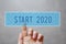 Finger pressing blue start 2020 button
