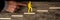 Finger pushing small yellow paper figure climbing steps