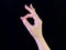 Finger sign, good sign. OK gesture with a female hand on a black background. Gesture of consent, approval