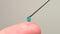 Finger touching medical syringe needle. Macro close up. Trypanophobia, extreme fear of injections or hypodermic needles.