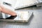 Finger Touching Mobile Phone With Reflection Next To A White Keyboard And A Biro On A Table - Office Meeting Concept