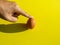 Finger touching or pointing fresh chicken egg isolated on yellow background