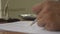 Finger writing doing calculation. Calculating balance audit or tax report with calculator. Close-up Defocused front Businessman