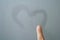 Finger written heart on frosted glass